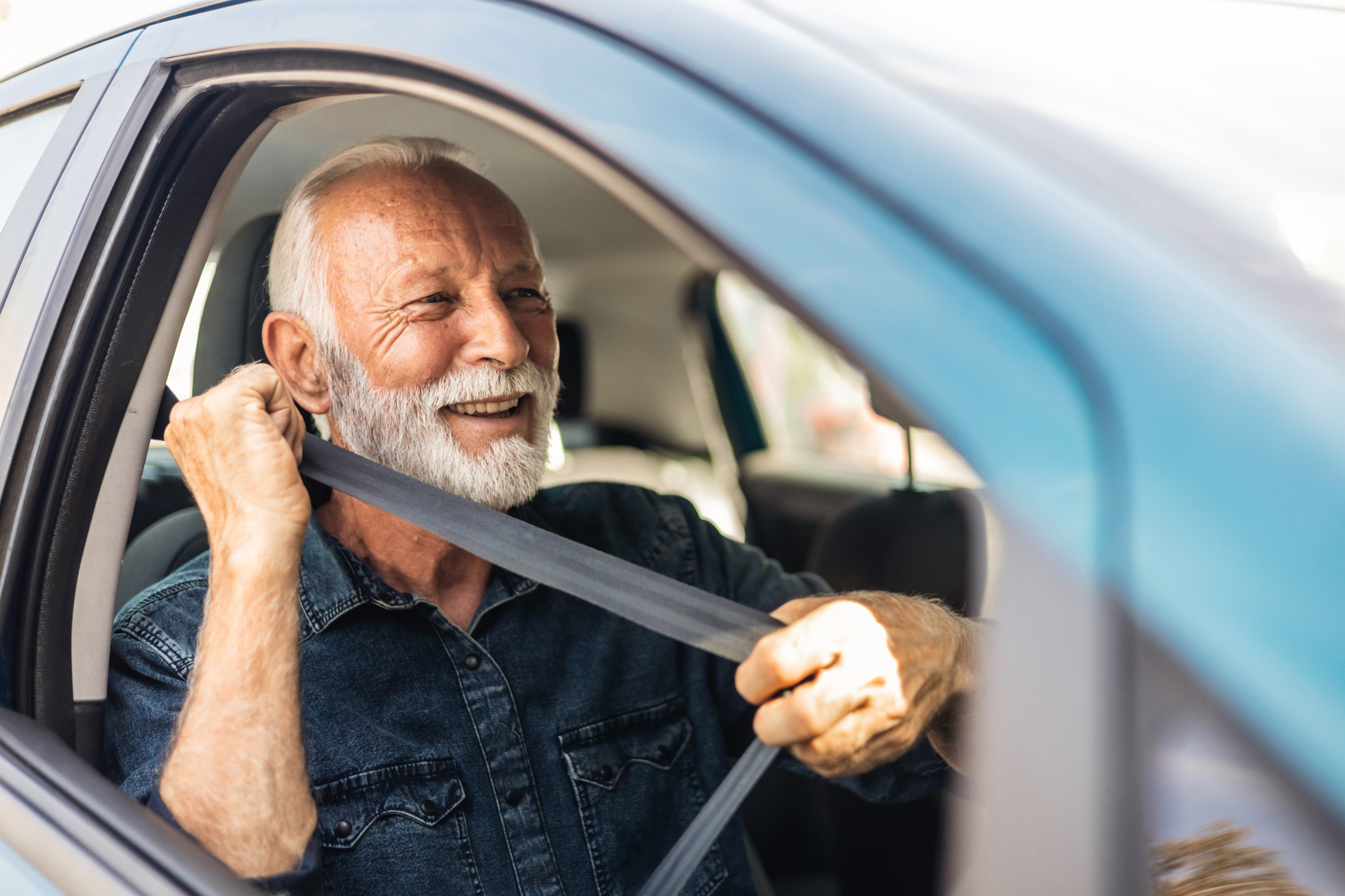 Portrait of smiling mature man driving his car. Close-up of man driving car.